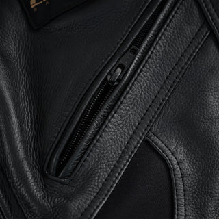 Close-up of a zippered pocket set into the black leather of the motorcycle trousers, highlighting the zipper track and the leather texture.