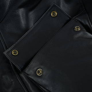 Extreme close-up of the leather texture and the four antique brass snap buttons securing the jacket's flap pockets.