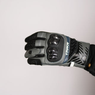 Close-up of the Stratus glove being worn, highlighting the glossy carbon fiber knuckle protectors, grey goatskin leather panels, and the textured mesh fabric sections.