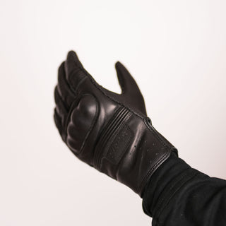 Side view of the glove being worn with fingers slightly extended, showing the hand's natural curve and the perforated leather cuff area.
