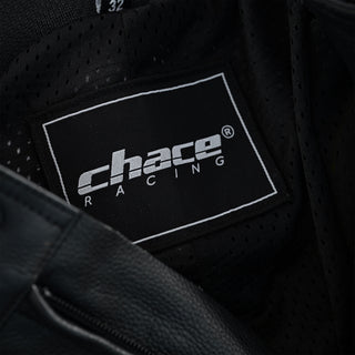 Close-up of the trousers' interior, showing the black breathable mesh lining and the woven white and black "Chace Racing" brand tag.