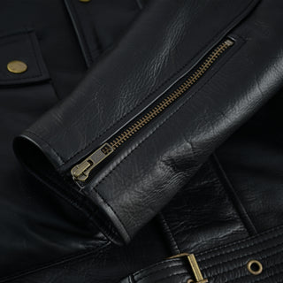 Close-up of the black leather sleeve cuff, showing a functional brass zipper used for cuff adjustment and a view of the jacket's belted waist in the background.
