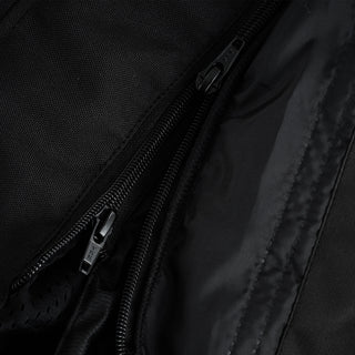 Extreme close-up of three parallel black zippers, indicating a triple-zipper system for the main closure, a storm flap, and a removable liner attachment.