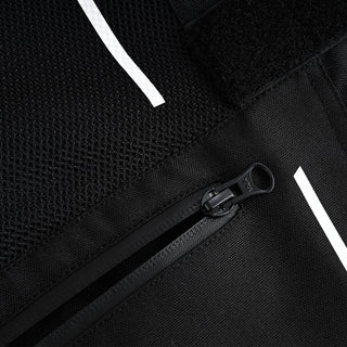 Close-up of a black zippered closure (pocket or vent) with a YKK pull tab, set below the main mesh panel and flanked by white reflective accent lines.